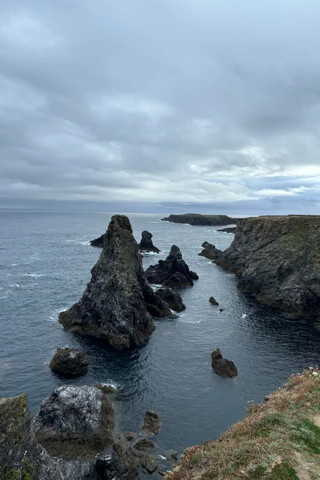 Aiguilles rocheuses de Port-Coton dressées dans la mer sous un ciel nuageux